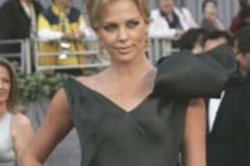 Charlize Theron a purtat o rochie Dior cu tăieturi asimetrice şi o fundă imensă pe un umăr