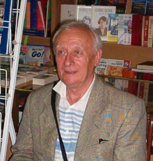 Artistul plastic Radu Bercea lângă standul cu carte românească