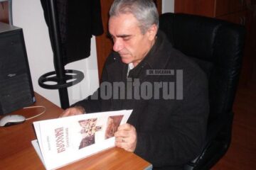 Nicolai Oprea răsfoind primul exemplar al lucrării