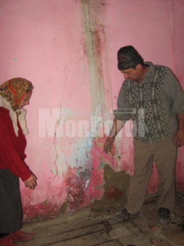 Soții Gheorghe, în casa avariata de dejecțiile provenite de la o fermă din apropiere