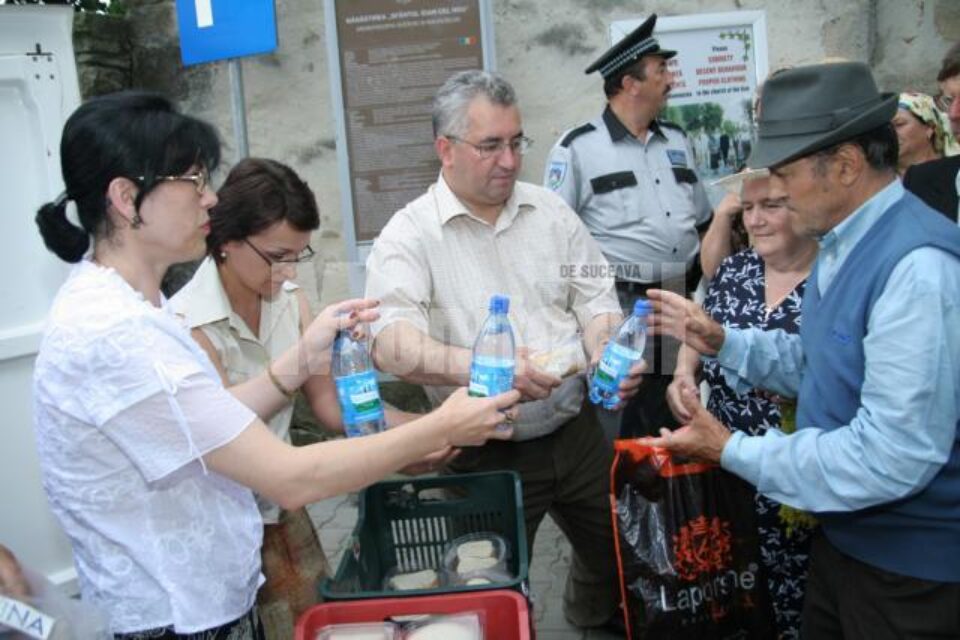 Ion Lungu și soția sa, împărțind sarmale și apă credincioșilor