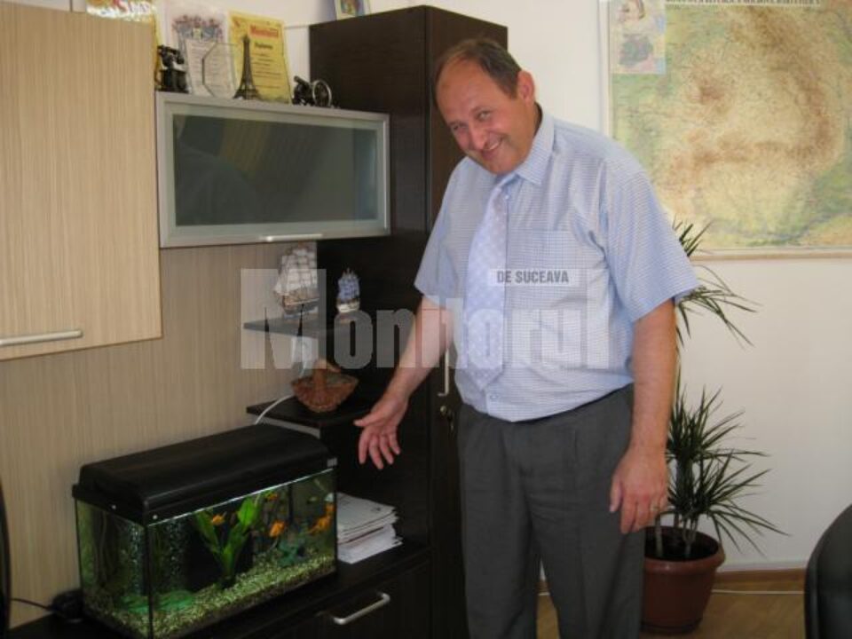 Primarul Andriciuc și acvariul cu cei 15 peștișori simbolizând Consiliul Local Șcheia
