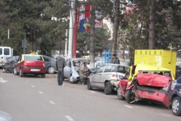 Trecătorii privesc mașinile transformate în mormane de fiare