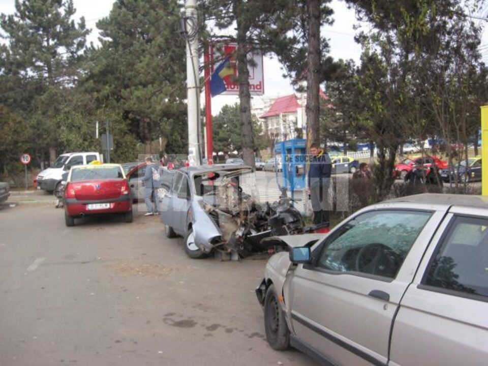 Oamenii se opresc si se uita la o Dacie distrusa aproape in totalitate