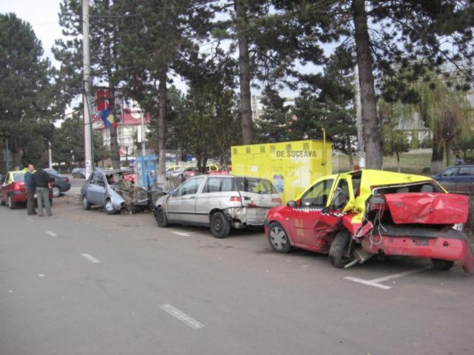 Trecătorii privesc mașinile transformate în mormane de fiare