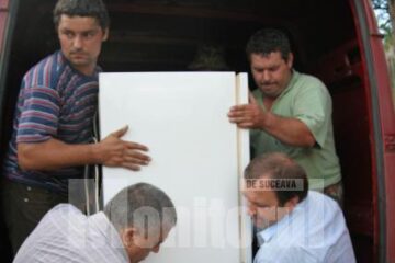 Gheorghe Flutur (dreapta) și Dumitrul Mihalescul (stânga) distribuind ajutoare sinistraților