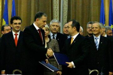 Presedintele PSD, Mircea Geoana (S), dă mâna cu președintele PD-L, Emil Boc (D), după semnarea Parteneriatului PD-L - PSD pentru România. Foto: MEDIAFAX