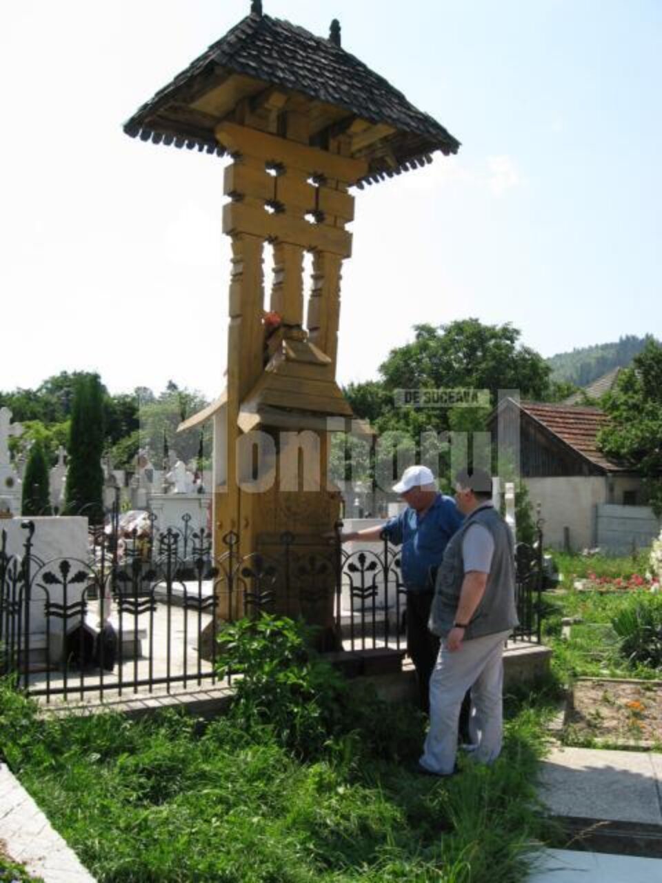 Ion Drăgușanul și Constantin Emil Ursu citind inscripția de pe troiță Ion Drăgușanul și Constantin Emil Ursu citind inscripția de pe troiță