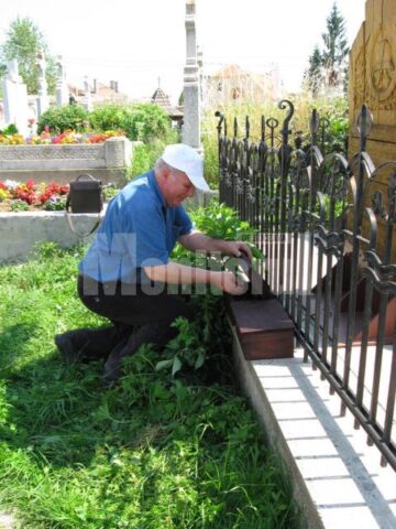 Ion Drăgușanul punând în casetă pământ de la baza troiței sub care sunt îngropate osemintele martirilor bucovineni