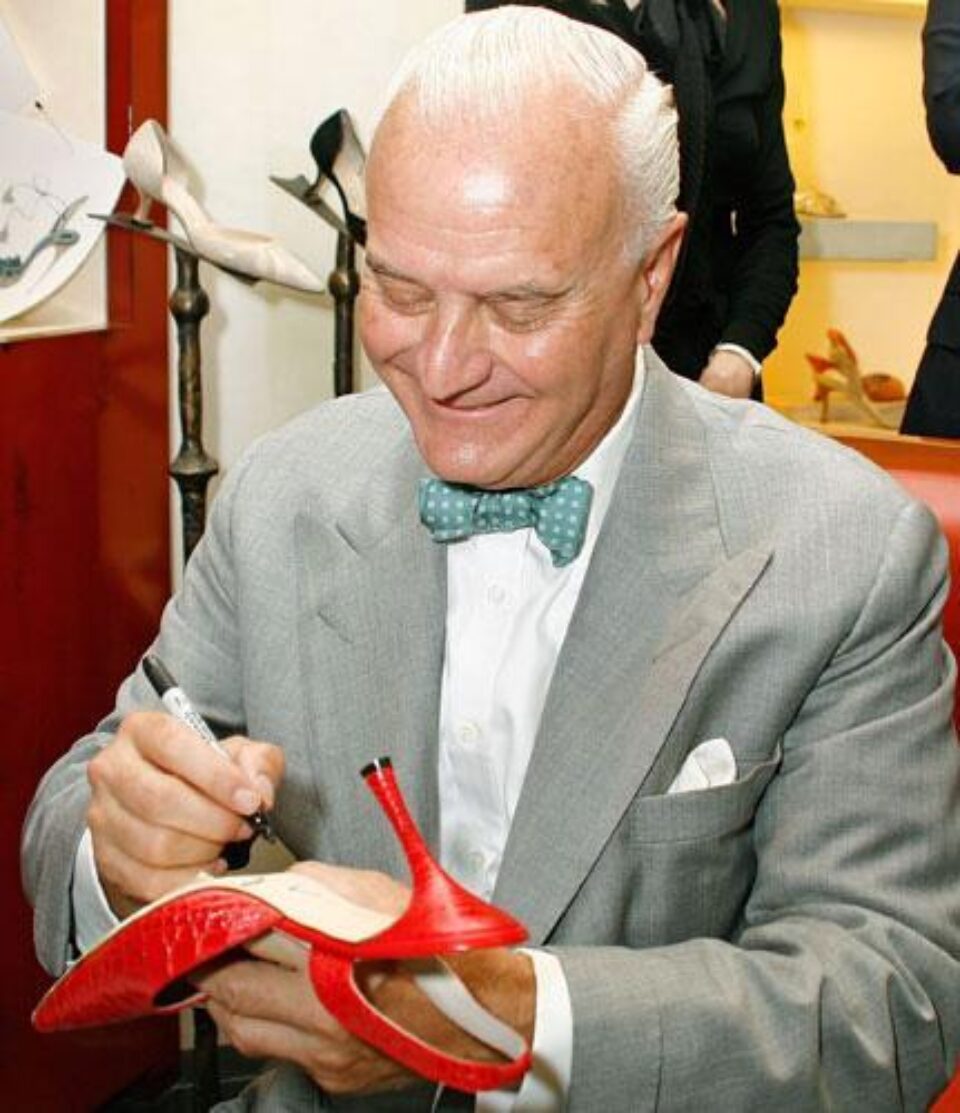Manolo Blahnik acordând un autograf pe una din creațiile sale. Foto: VIRGIN MEDIA