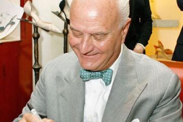 Manolo Blahnik acordând un autograf pe una din creațiile sale. Foto: VIRGIN MEDIA