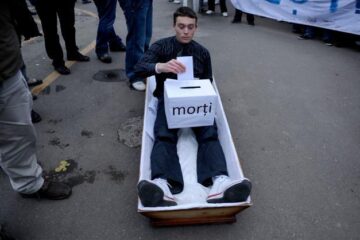 Studenții au dus în fața Palatului Cotroceni un sicriu în care stătea un tânăr simulând procesul de vot. Foto: MEDIAFAX