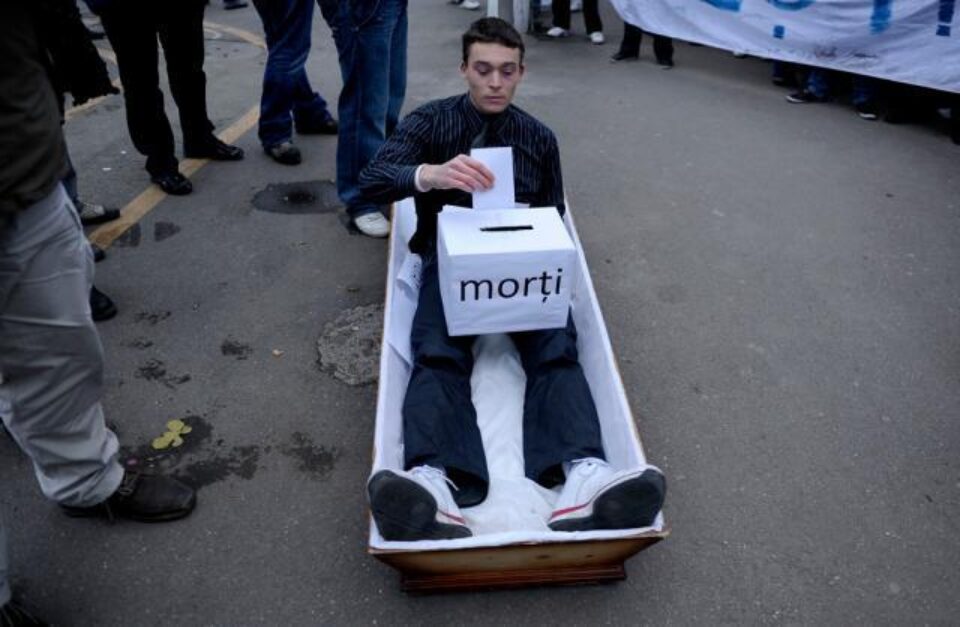 Studenții au dus în fața Palatului Cotroceni un sicriu în care stătea un tânăr simulând procesul de vot. Foto: MEDIAFAX