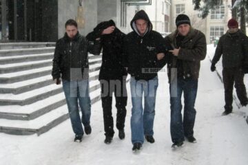 Doi dintre suspecți, flancați de polițiști, ieri, la ieșirea din sediul Parchetelor
