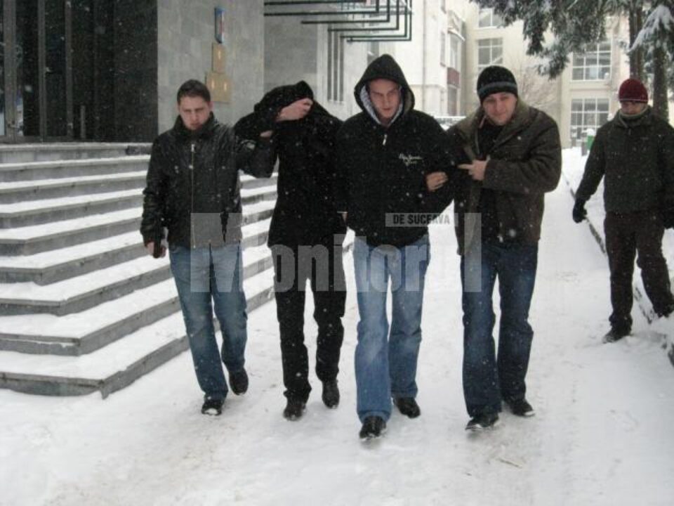 Doi dintre suspecți, flancați de polițiști, ieri, la ieșirea din sediul Parchetelor