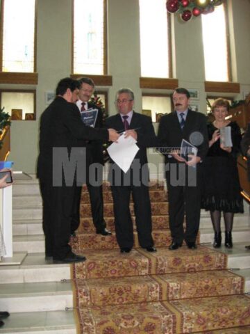 Directorul Constantin Emil Ursu înmânându-i primarului Ion Lungu diploma și medalia aniversară