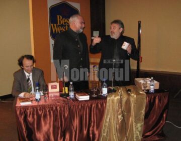 Primarul Marius Ursaciuc oferindu-i autorului cănile cu inscripția Bea-ți cafeaua cu Varujan