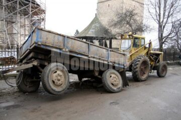 Remorca aflată în spatele unui tractor a rămas înțepenită după ce o roată s-a afundat în pământul cu care fusese acoperită o groapă