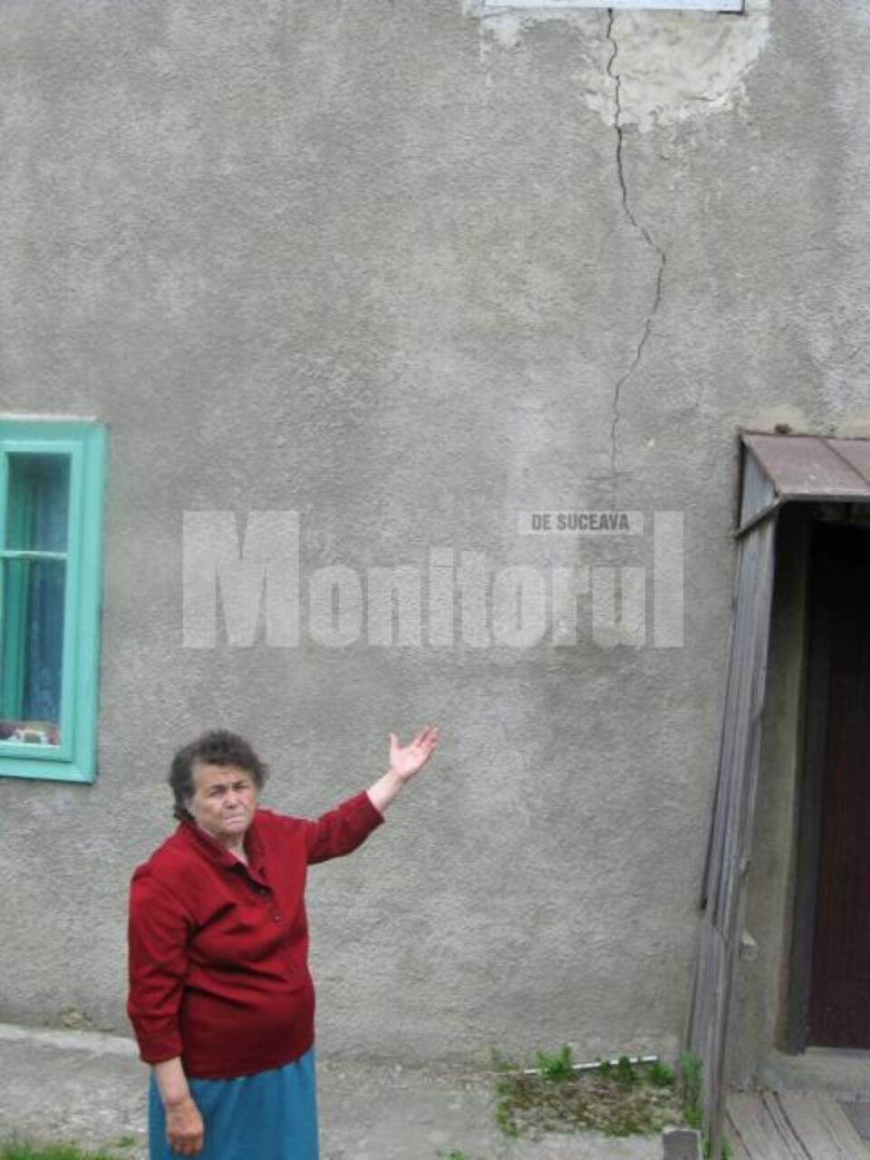 Ioana Răstoacă arată cu tristețe către una din crăpaturile apărute în zidul casei sale Ioana Răstoacă arată cu tristețe către una din crăpaturile apărute în zidul casei sale