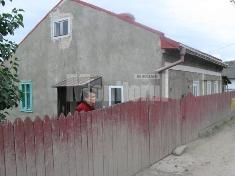 Gardul si casa Ioanei Răstoacă, acoperite de noroiul aruncat din gropi de rotile mașinilor