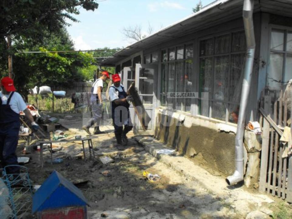 Îndepărtarea nămolului din casele inundate, cu ajutorul voluntarilor de la E.ON