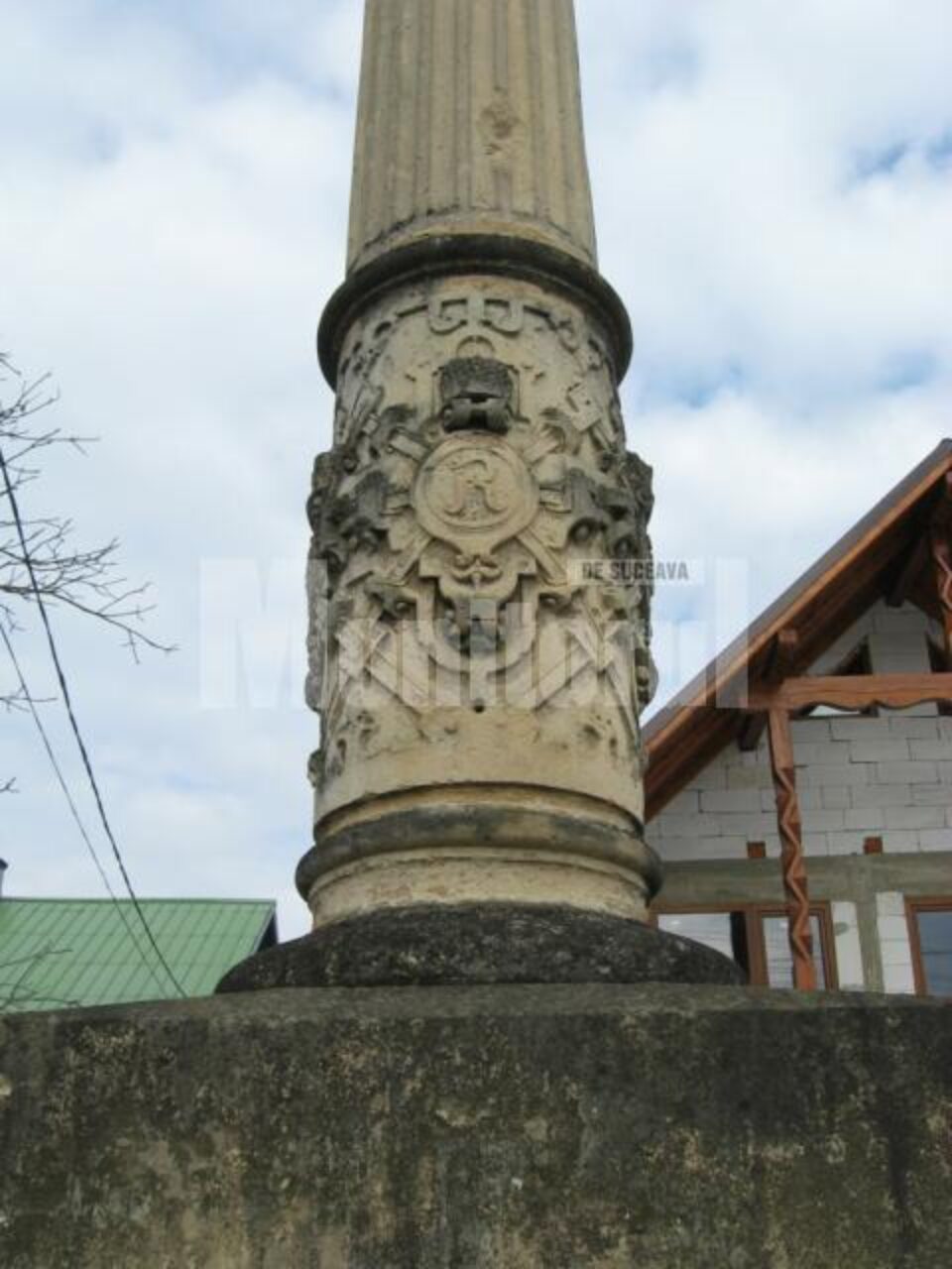 Pe porțiunea ornamentată de la baza coloanei se află patru medalioane cu litera R