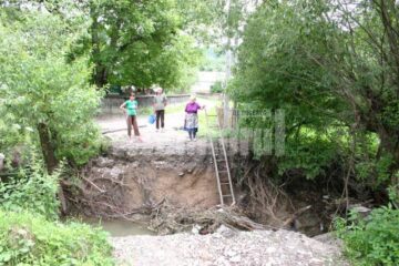 Singura cale de acces a localnicilor din zona rămasă izolată este o scară de lemn pe care oamenii au coborât-o în hăul format în locul podului