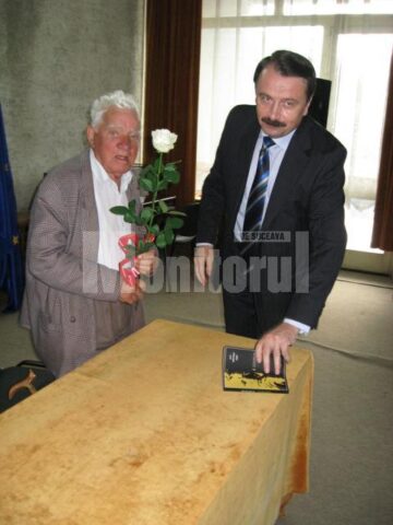 George Ungureanu, cu trandafirul alb oferit de vicepreședintele CJ Suceava, Vasile Ilie