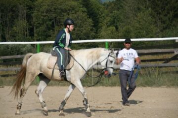 Ionel Moroșan, în timp ce îl invață pe unul dintre copii să meargă pe cal