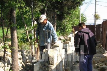 Partea zidită a gardului este executată din piatră de la cariera din Vama