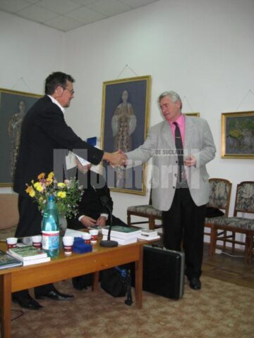 Mugur Andronic felicitându-l pe cercetătorul Vasile Schipor - Crucea de Aur la secțiunea Științe istorice