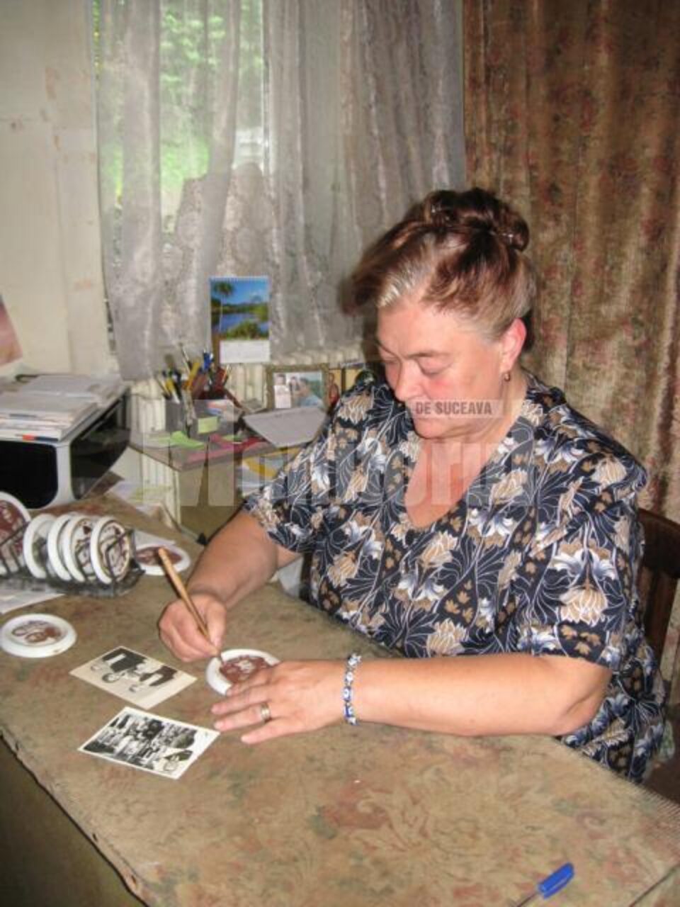 Doina Balan curățând cu creionul de paltin imaginea transpusă pe suportul ceramic