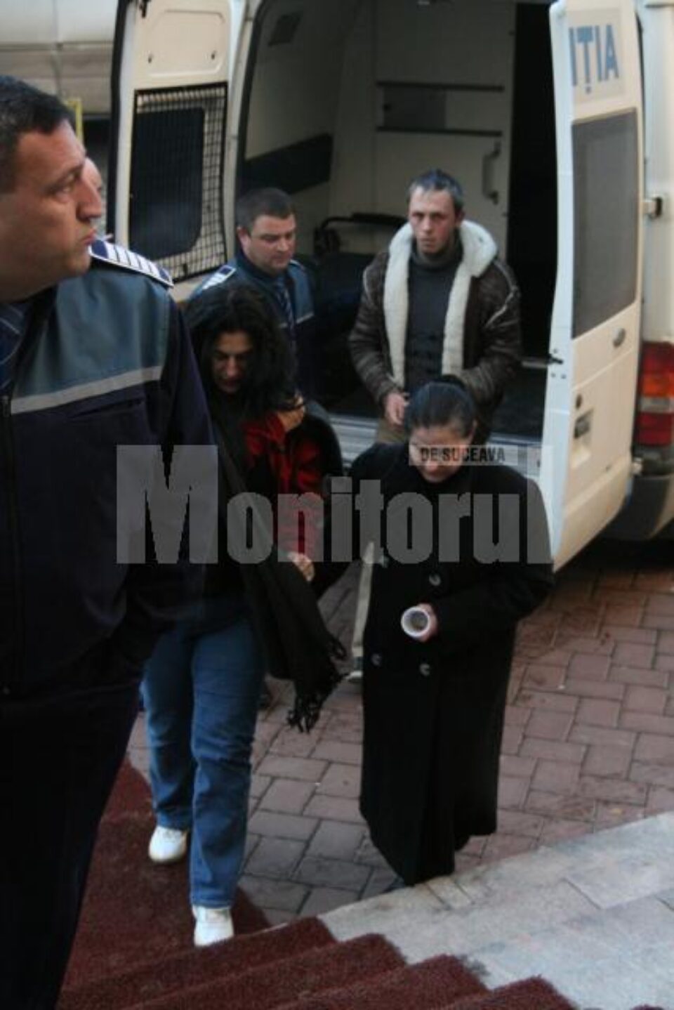 Cei trei suspecți, scoși din duba Arestului și duși în fata judecătorilor cu propunere de arestare preventivă