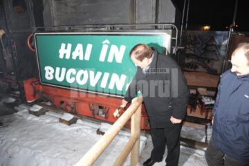 Gheorghe Flutur dă semnalul de pornire al mocaniței spărgând o sticlă de șampanie