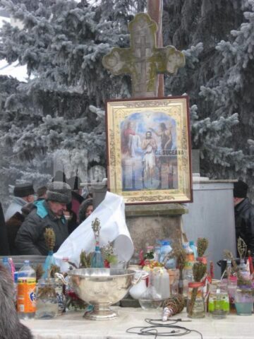Recipientele cu apa pentru sfintit asezate pe masa din curtea Manastirii Sf Ioan cel Nou