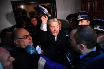 Liderul Partidului România Mare (PRM), Corneliu Vadim Tudor (C), ameniță un polițist, în sediul PRM din Bucuresti. Foto: Octav GANEA / MEDIAFAX FOTO