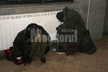 Oameni ai străzii ghemuiți lângă calorifere, în Gara Burdujeni