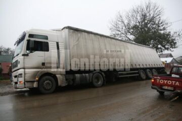 Unul dintre tirurile rămase blocate, cu roțile afundate în șanț