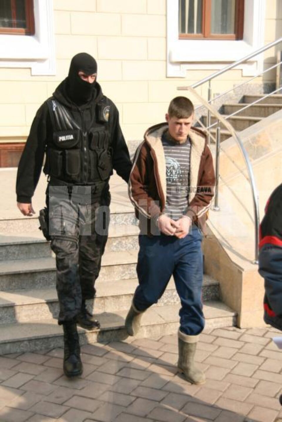 Benone Andrei Popa urmându-și mama în arestul poliției