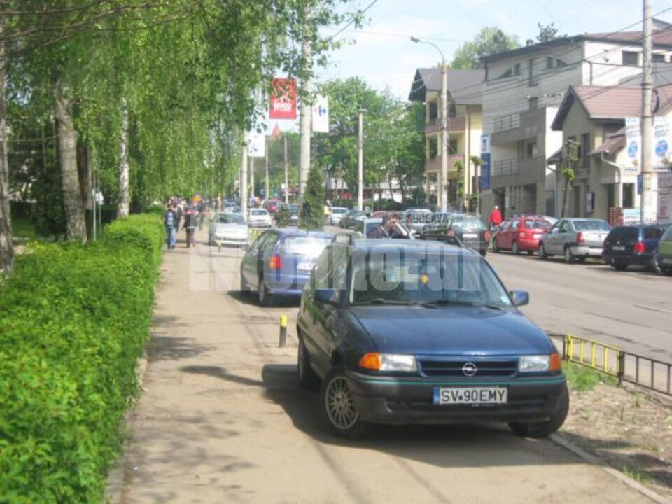 Mașinile înșirate pe trotuar, ieri dimineață, în jurul orei 11.00