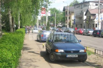 Mașinile înșirate pe trotuar, ieri dimineață, în jurul orei 11.00