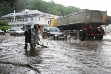 Pompierii intervenind la desfundarea străzii, la ieșirea din oraș spre Ipotești, la Uzină