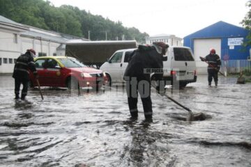 Pompierii intervenind la desfundarea străzii, la ieșirea din oraș spre Ipotești, la Uzină