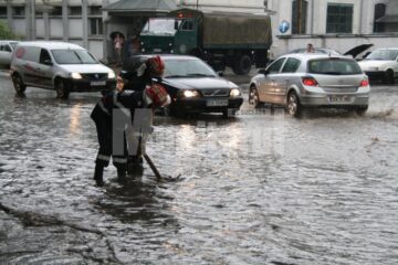 Pompierii intervenind la desfundarea străzii, la ieșirea din oraș spre Ipotești, la Uzină
