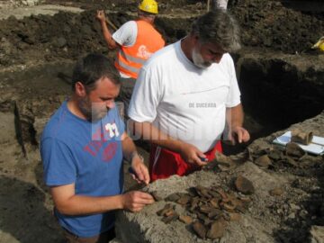 Arheologii Sorin Dejan și Florin Hău și câteva fragmente de ceramică descoperite