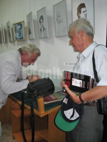 Compozitorul și dirijorul Emil Havriliuc oferindu-i un autograf prof. Gheorghe Giurcă