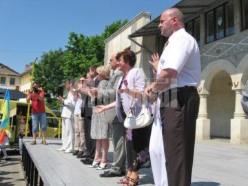 Reprezentanți ai organizatorilor și oficialități aplaudând parada portului popular