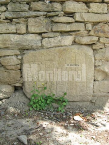 Piatră cu semne incizate încastrată în zid
