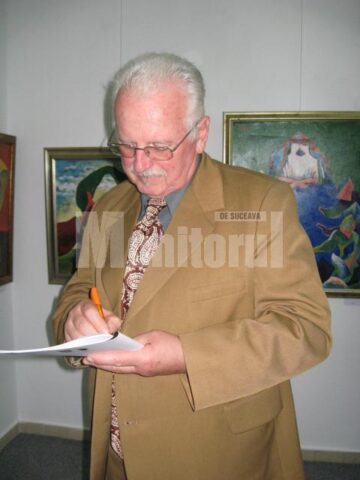 Liviu Suhar oferind o dedicație cu autograf pe catalogul expoziției