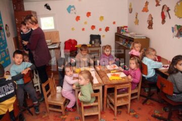 Copiii de la această grădiniță se înghesuie într-o cameră mică și se încălzesc la plită